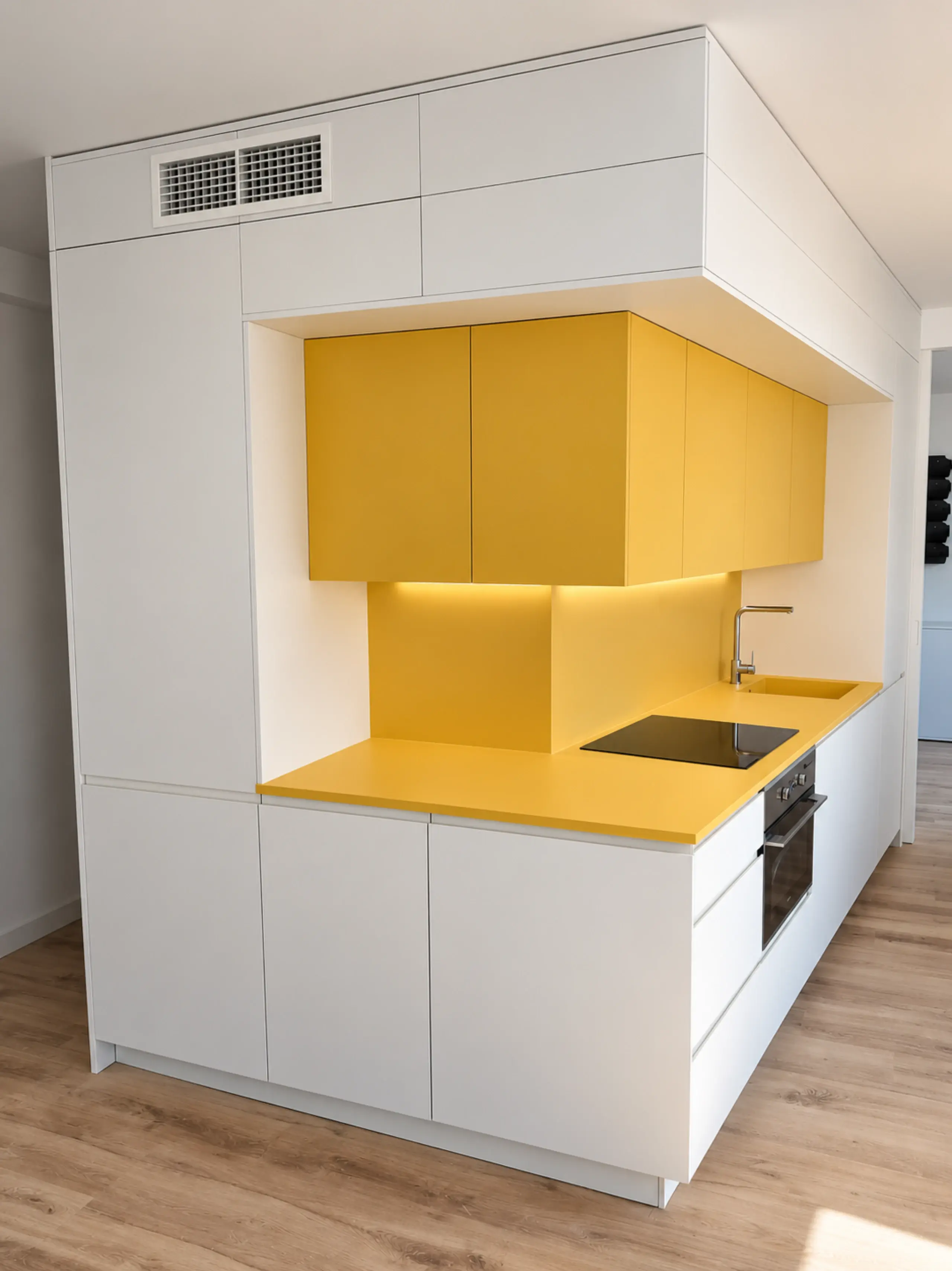 Bloque de cocina blanco con un nicho en amarillo para la zona de trabajo