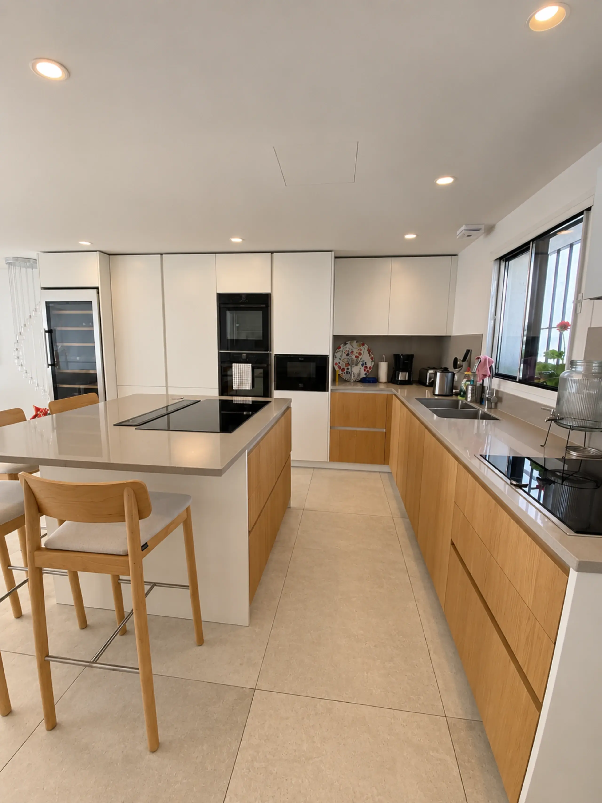 Cocina blanca y madera con isla y sillas de madera