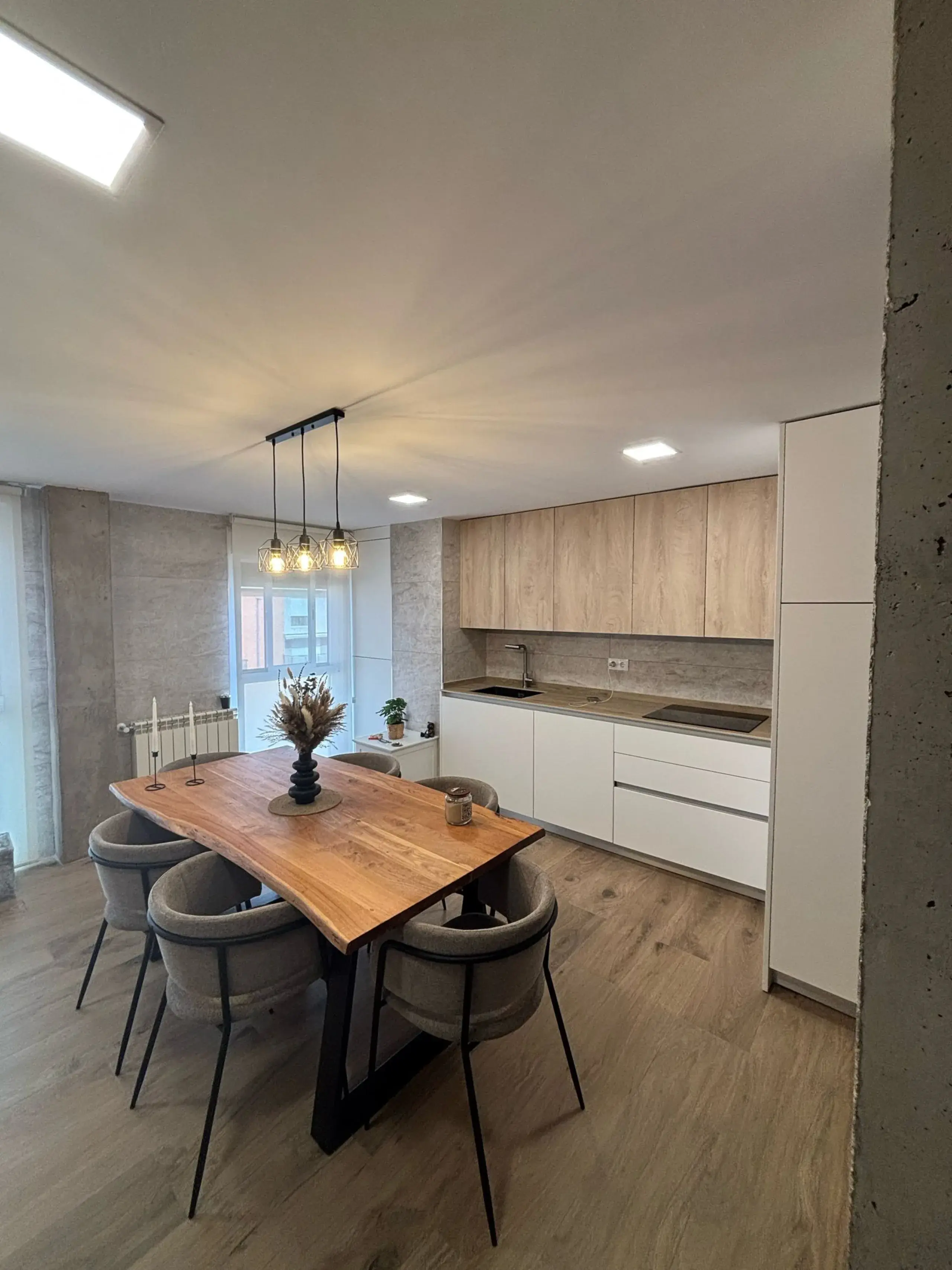 Muebles altos de madera sobre muebles bajos blancos, con la mesa de comedor delante