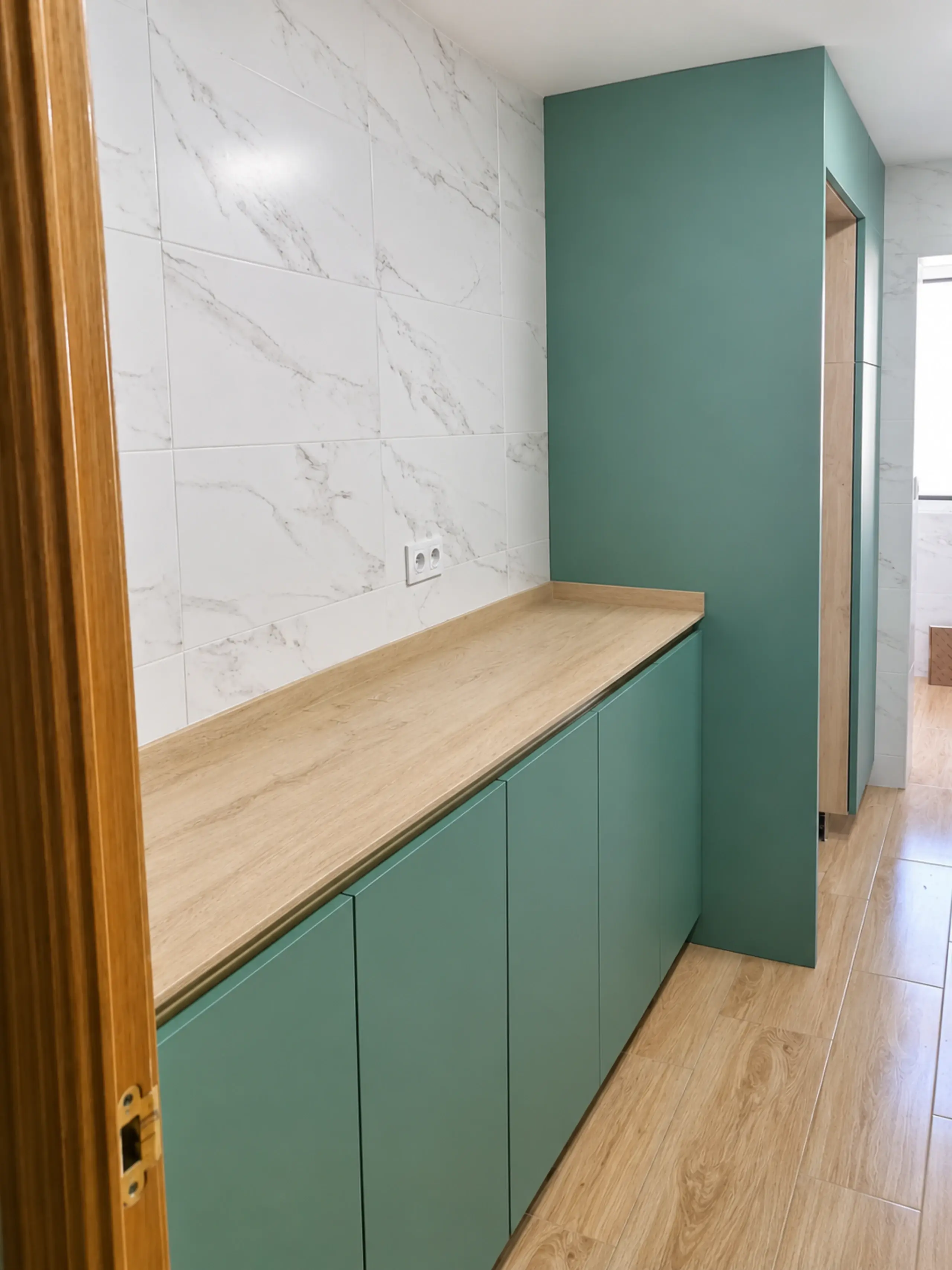 Segundo frente en verde con encimera de madera y revestimiento de efecto mármol