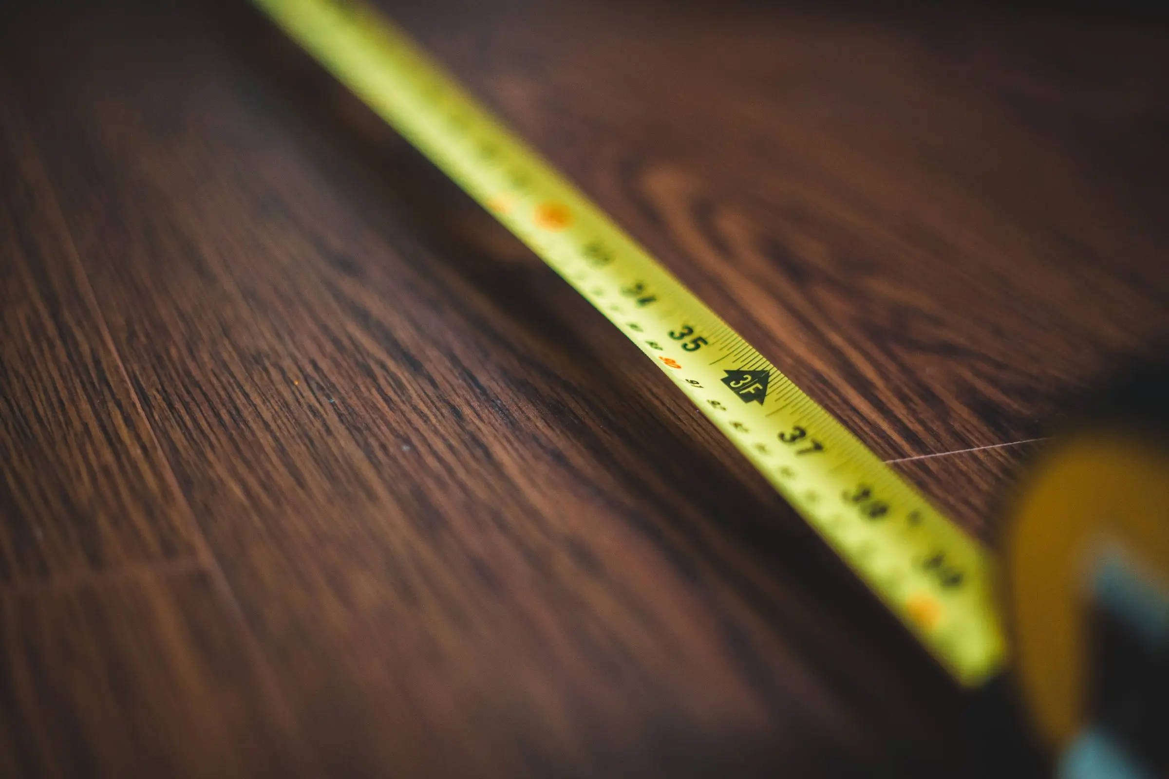 Cinta métrica extendida sobre una superficie de madera
